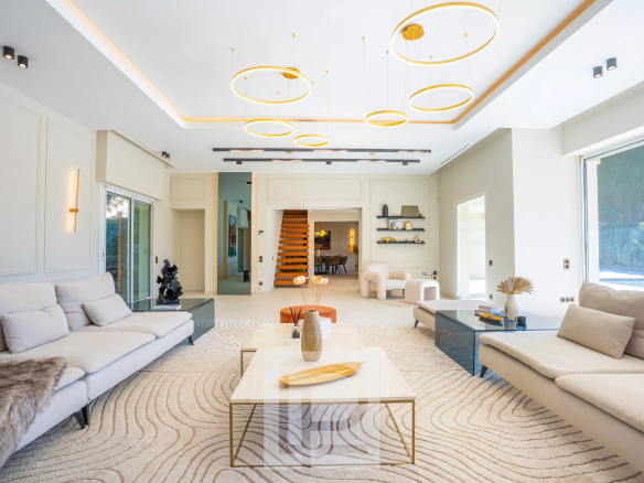 Intérieur d'une villa contemporaine avec un grand salon lumineux et des meubles modernes.
