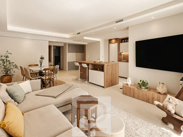 Intérieur d'un appartement rénové avec salon, cuisine ouverte et espace repas.