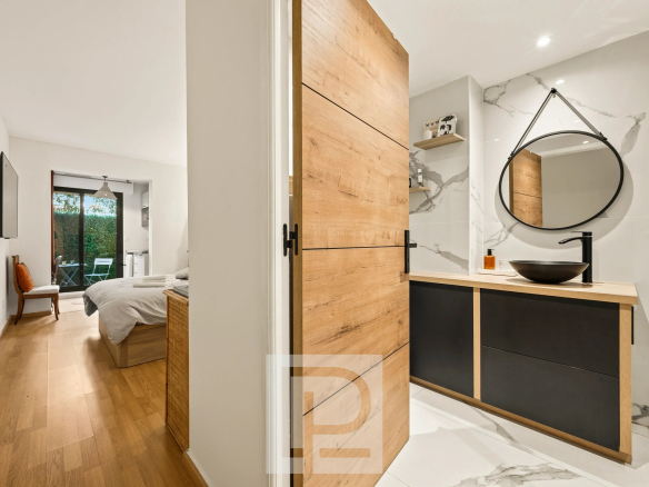 Salle de bain moderne avec meuble en bois et miroir, vue sur une chambre à coucher