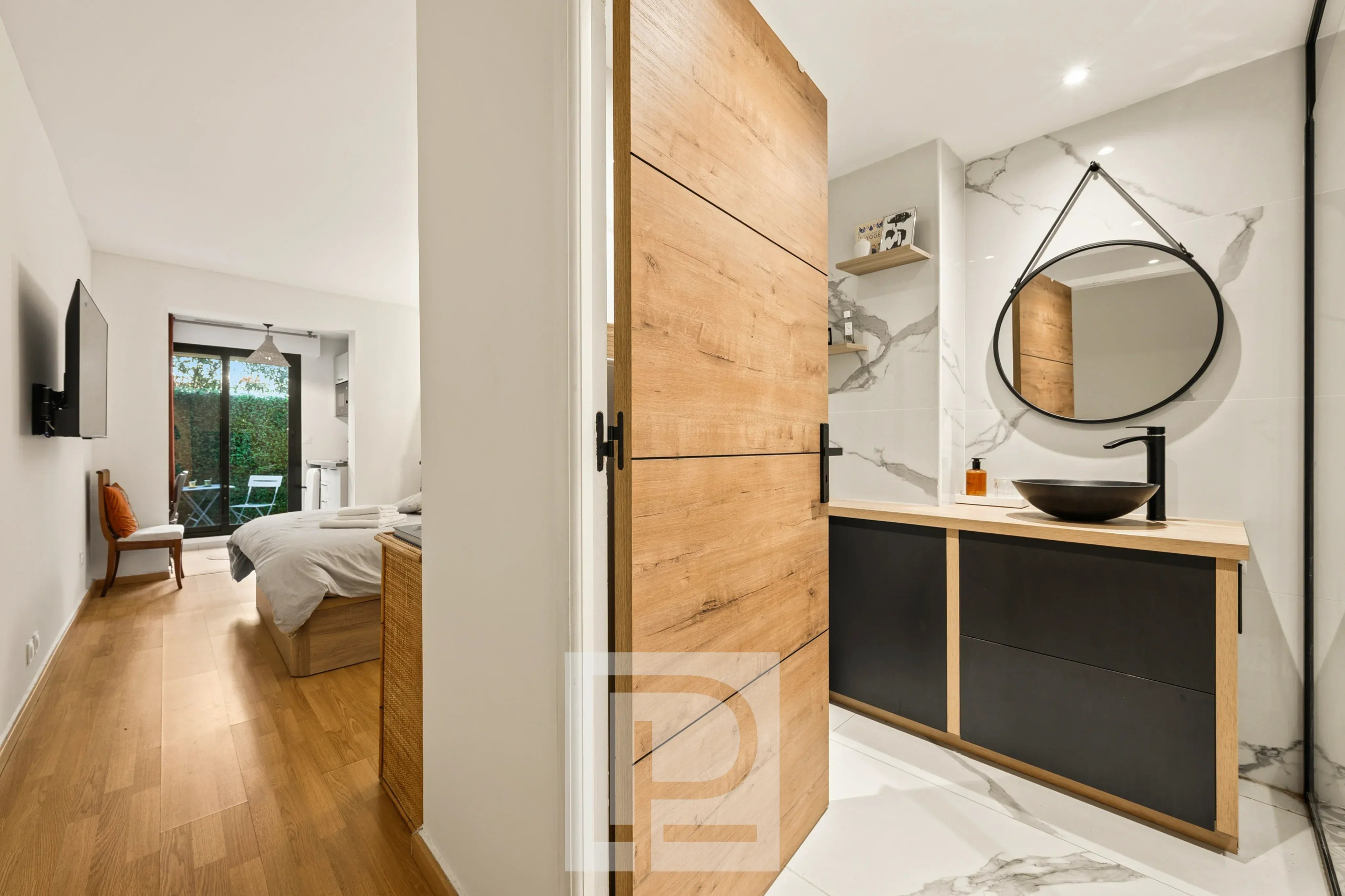 Salle de bain rénovée dans un appartement élégant Salle de bain moderne avec meuble en bois et miroir, vue sur une chambre à coucher