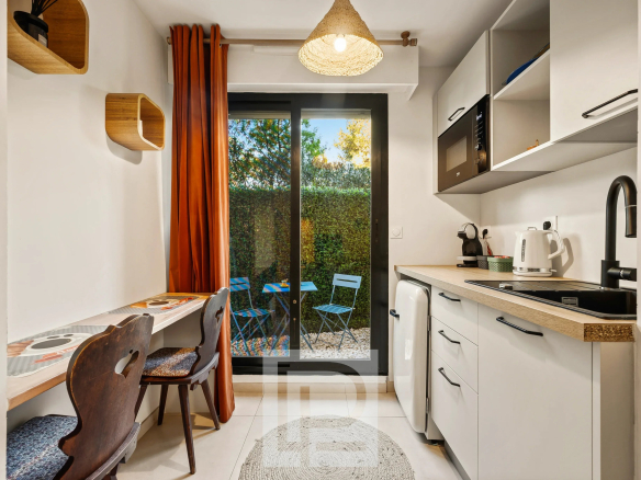 Cuisine moderne avec coin repas, accès à un jardin, dans un appartement rénové à Le Cannet.