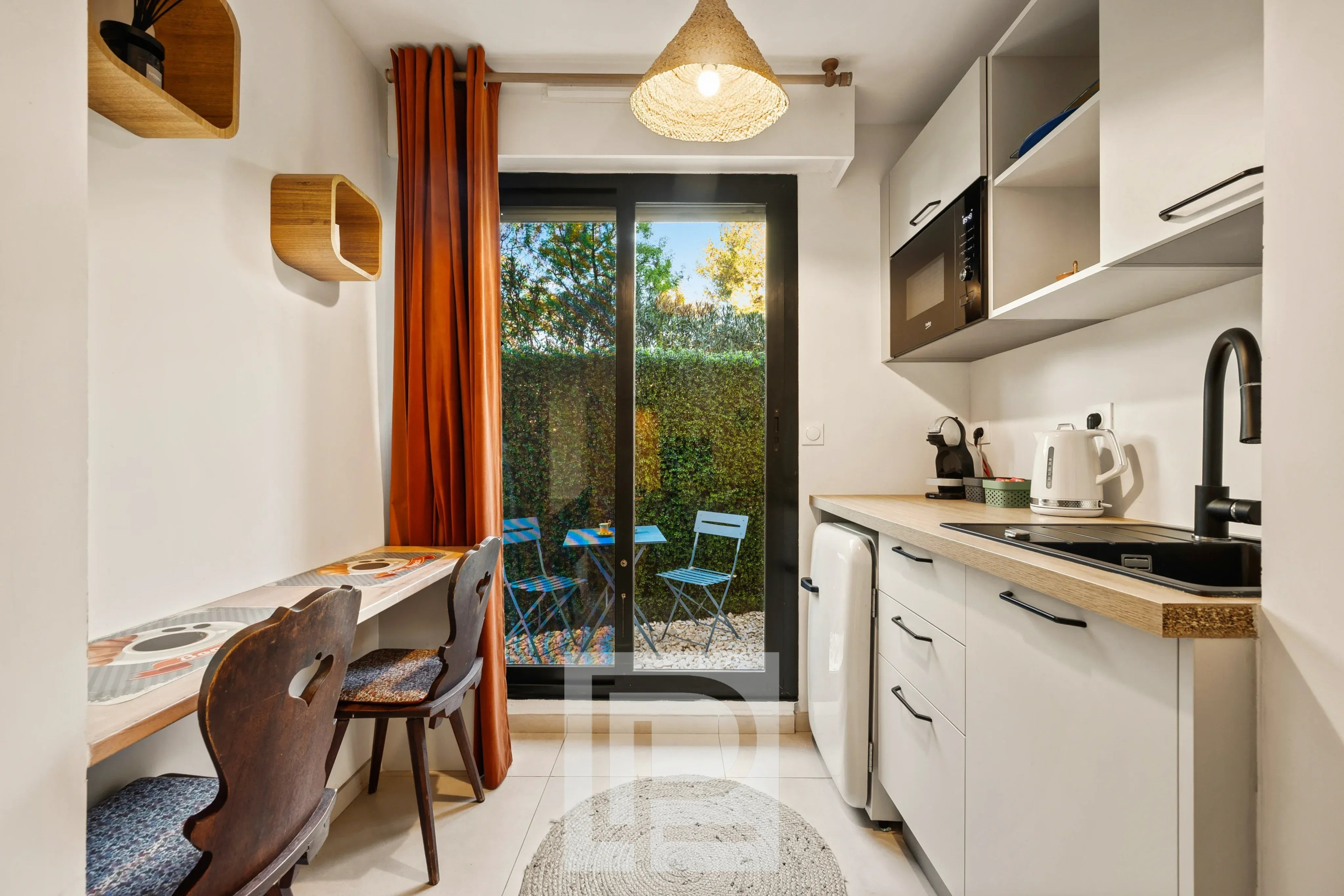 Cuisine rénovée avec accès jardin Cuisine moderne avec coin repas, accès à un jardin, dans un appartement rénové à Le Cannet.