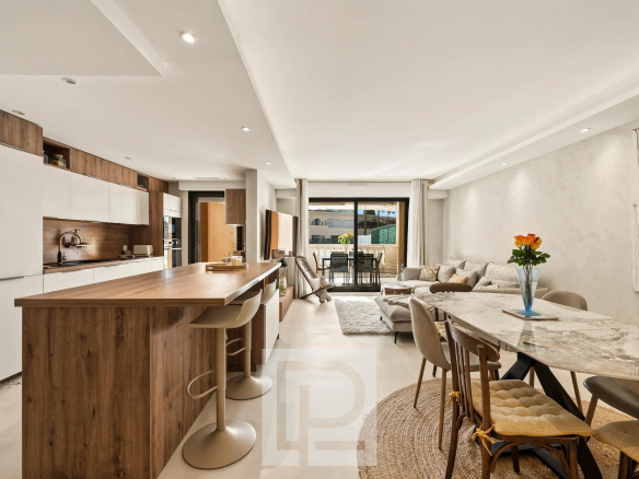 Intérieur d'un appartement rénové avec cuisine ouverte, salon et salle à manger, lumineux et moderne.