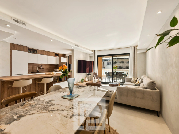Intérieur d'un appartement rénové avec salon, cuisine ouverte et salle à manger.
