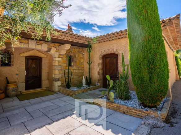 Entrance to an elegant property with cacti and stone walls in Mouans-Sartoux.