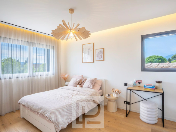 Chambre d'une villa contemporaine à Mougins, avec lit, fenêtre et décoration moderne.