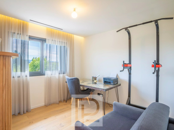 Bureau moderne avec un bureau en verre, une chaise et un équipement de fitness dans une villa contemporaine.