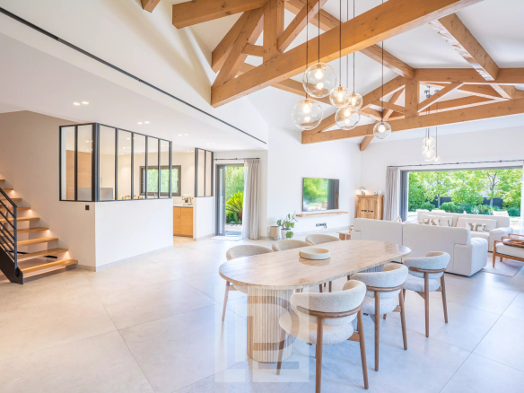 Intérieur d'une villa contemporaine avec un salon lumineux et une salle à manger moderne.