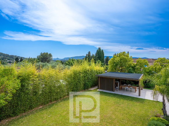 Vue d'une villa contemporaine avec jardin paysager à Mougins, ciel dégagé et espace extérieur.