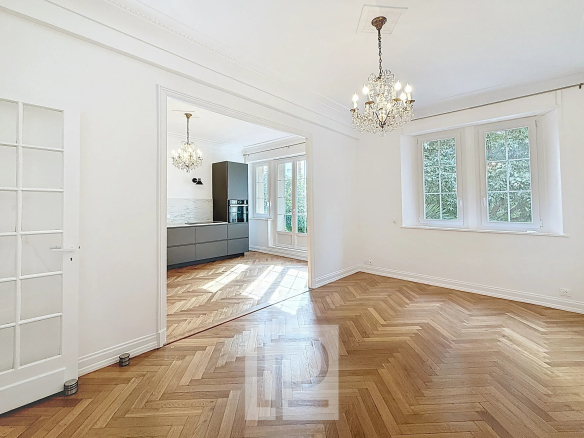 Intérieur d'un appartement rénové avec parquet en chevron et luminaires, à Cannes.