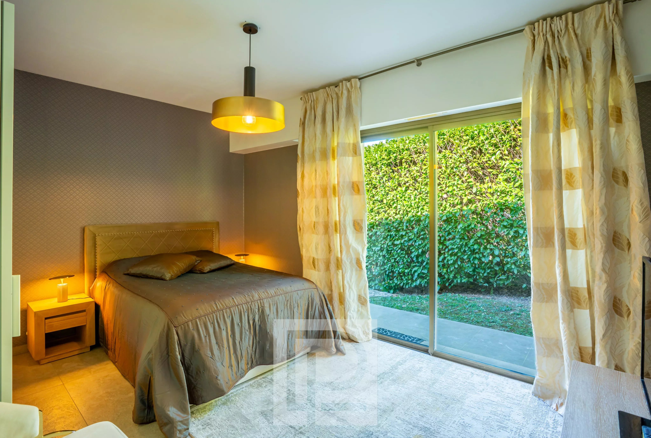 Chambre d'une villa Californienne à Vallauris avec lit double et accès extérieur.