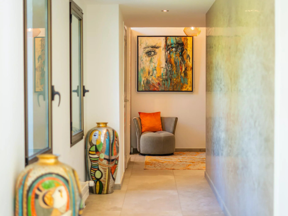 Intérieur d'une villa californienne avec couloir décoré et œuvres d'art.