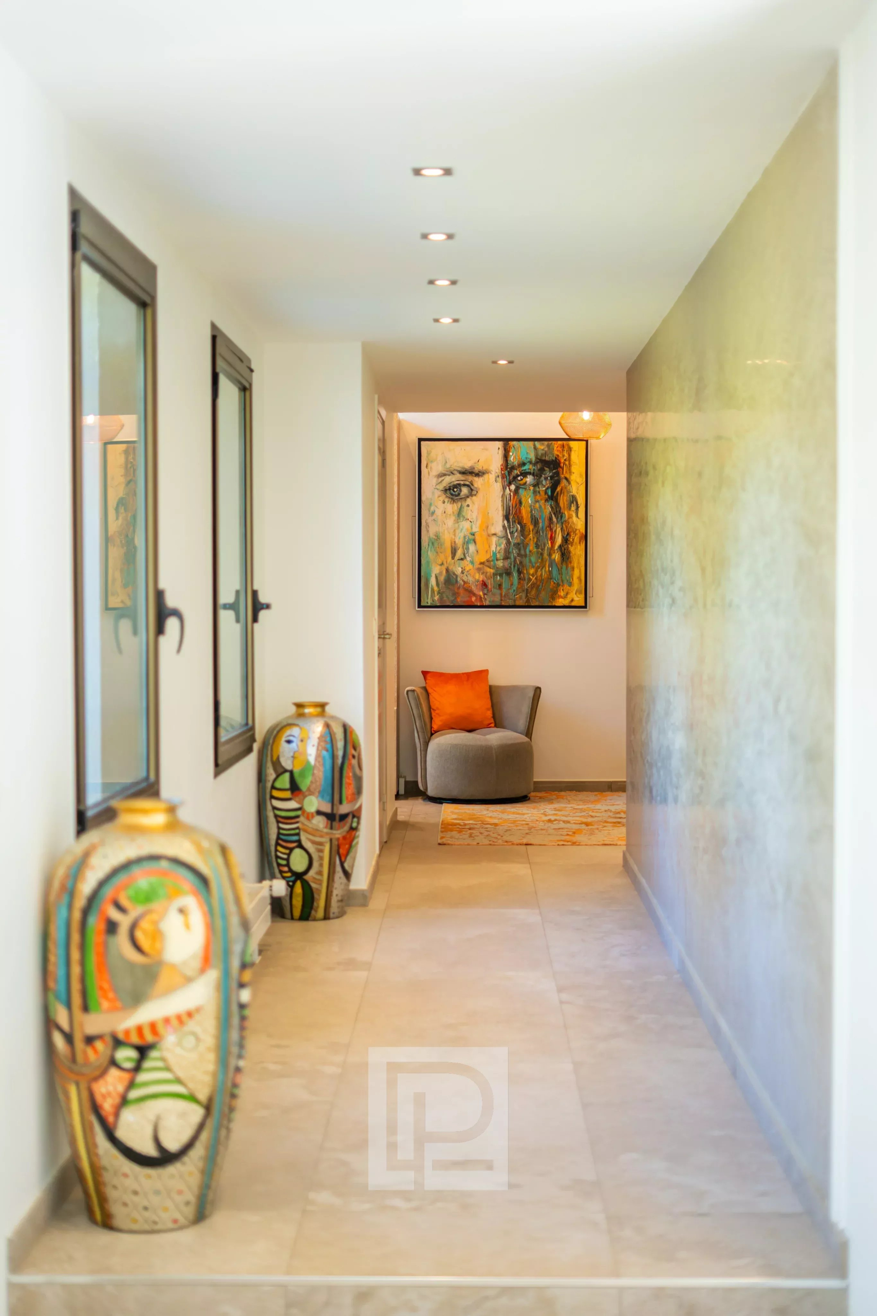 Intérieur d'une villa californienne avec couloir décoré et œuvres d'art.