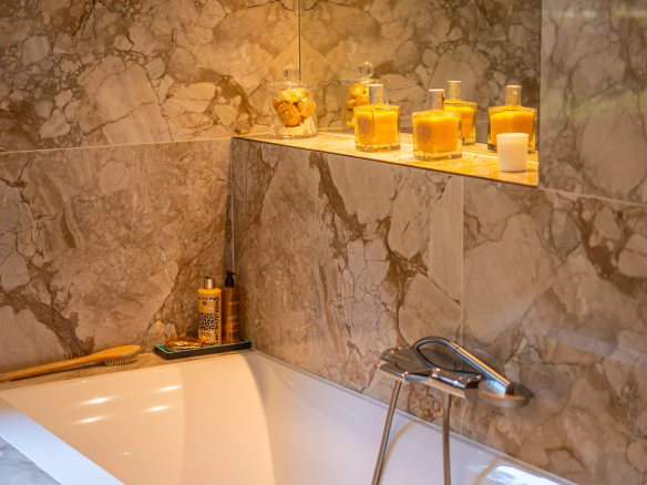 Salle de bain moderne avec baignoire et décor en marbre.
