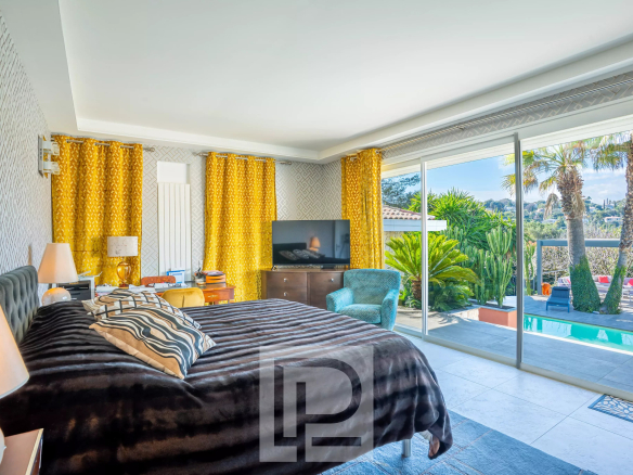 Chambre d'une villa Californienne avec vue sur la piscine et jardin.