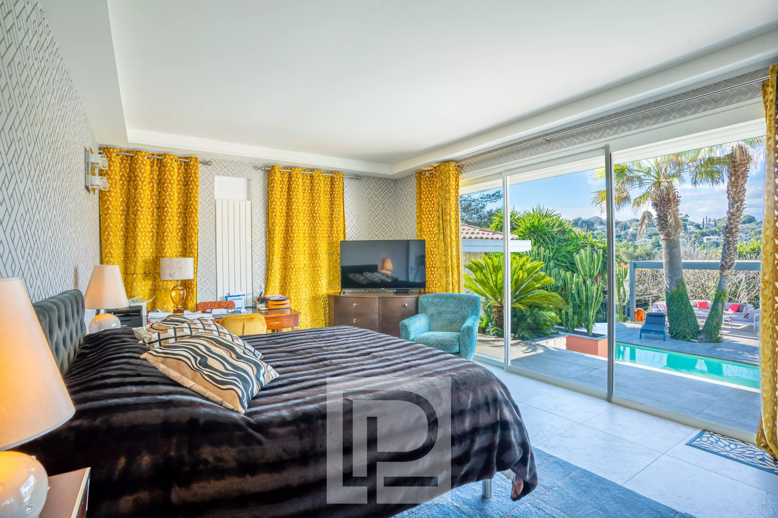 Chambre d'une villa Californienne avec vue sur la piscine et jardin.