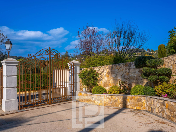 Entrance to a villa with wrought iron gate and landscaping in Mougins.