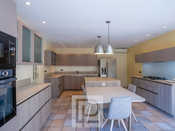Modern and spacious kitchen in a villa in Mougins, with wooden furniture and contemporary lighting.