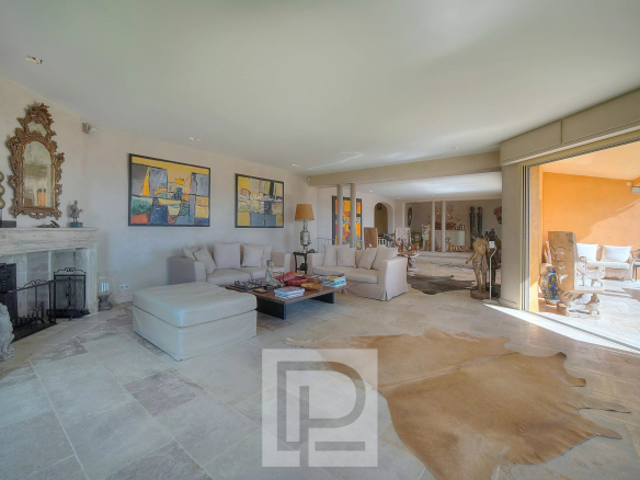 Intérieur d'une villa à Mougins avec salon spacieux et luminosité, vue sur l'extérieur.