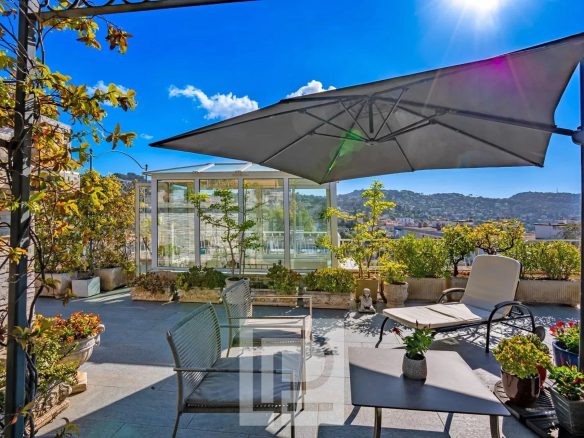 Terrasse panoramique d'un appartement rénové au dernier étage avec vue sur la ville et la mer.