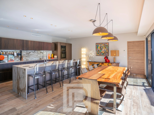 Intérieur d'une villa contemporaine à Mougins avec cuisine moderne et salle à manger lumineuse.