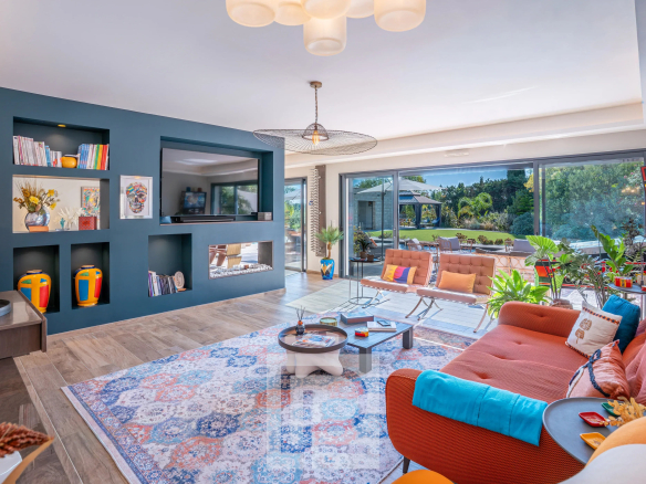 Intérieur d'une villa contemporaine à Mougins, salon spacieux avec grandes fenêtres et décoration colorée.
