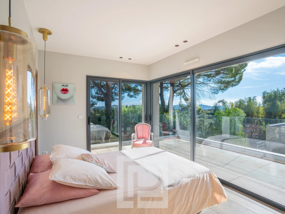 Chambre lumineuse d'une villa contemporaine avec vue sur les collines à Mougins.