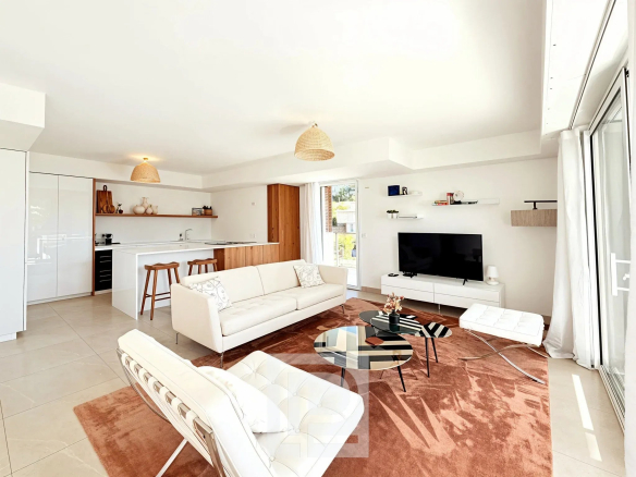 Bright living room of a modern apartment with open kitchen and contemporary furniture.