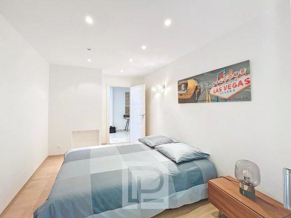 Chambre d'un appartement moderne avec lit double et décoration murale à thème Las Vegas.