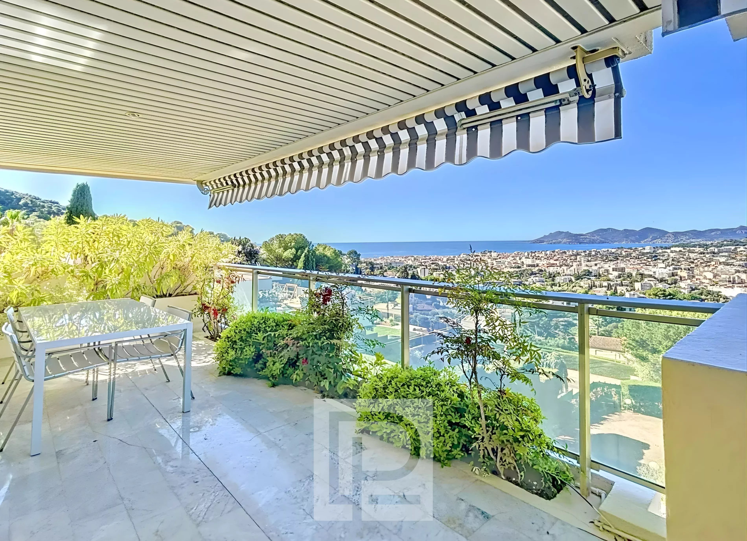 Terrasse avec vue mer au Cannet Terrasse d'un appartement avec vue panoramique sur la mer au Cannet, entourée de verdure.