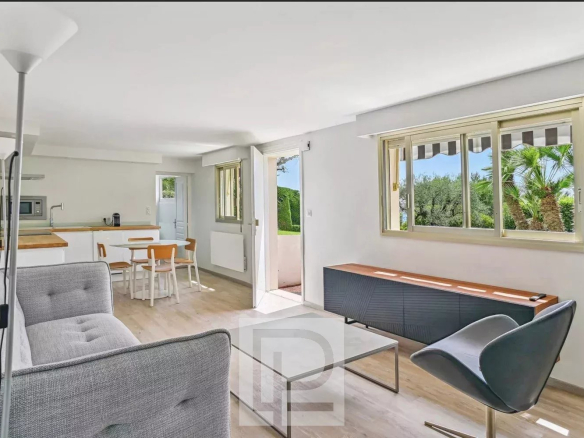 Intérieur d'un appartement moderne avec salon lumineux et vue sur la mer.