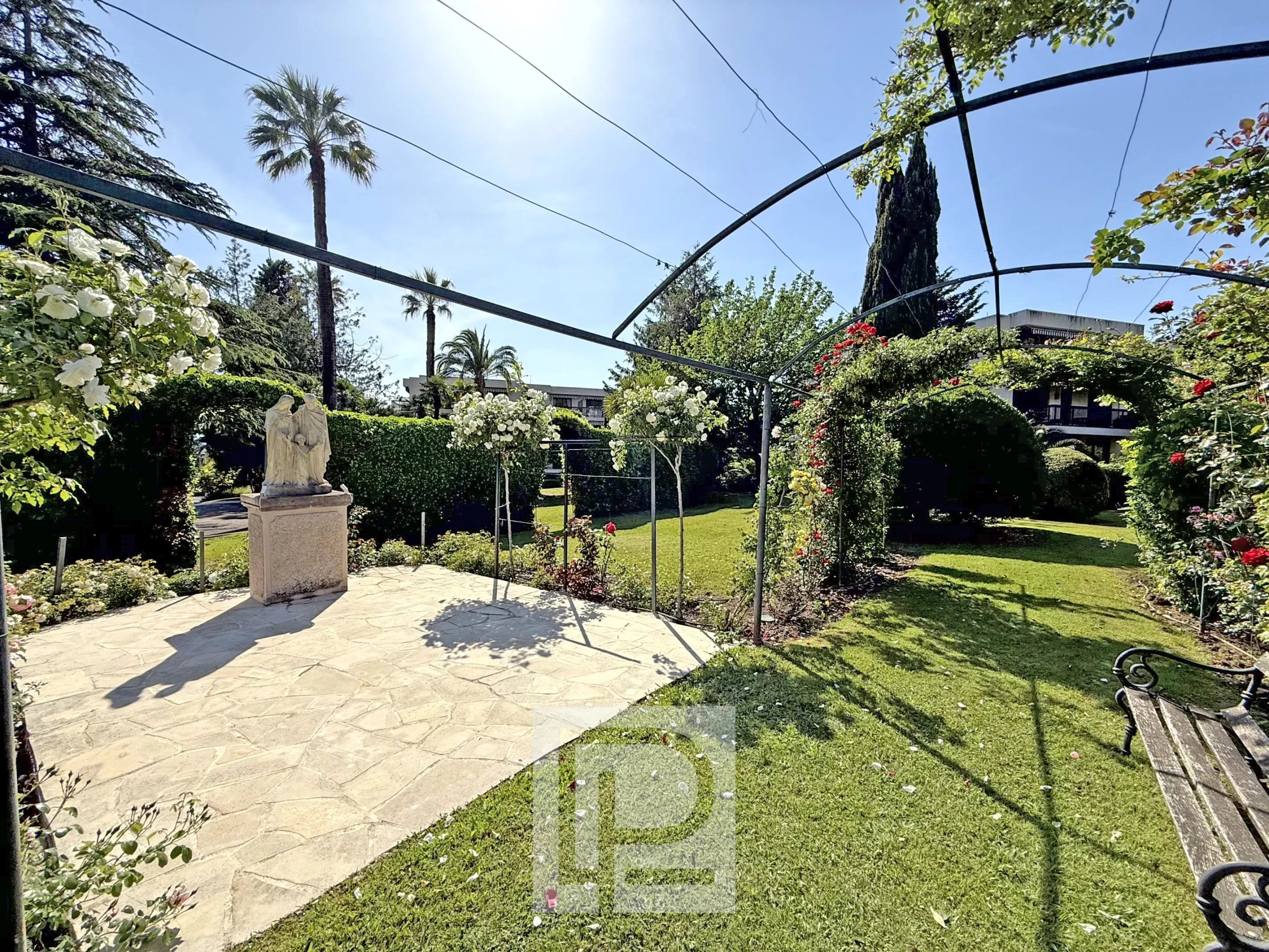 Garden in the Montrose district of Cannes Green garden with statue and lawn in a residential area in Cannes.