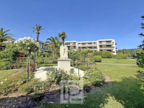 Garden with statue and buildings in the background in the Montrose district of Cannes.