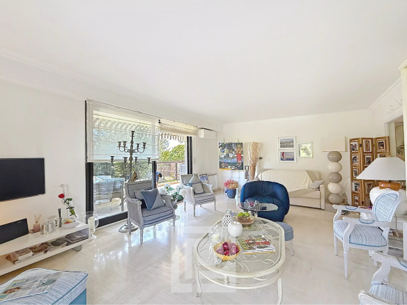 Interior of a bright apartment with living room, sofa and view of a park.