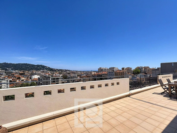 Terrace of an apartment in Cannes with views of the city and surrounding landscape.