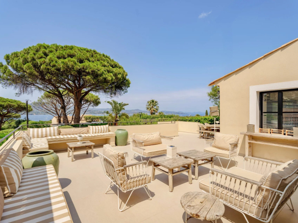 Terrasse d'une villa avec vue mer à Gassin, mobilier de jardin et végétation environnante.