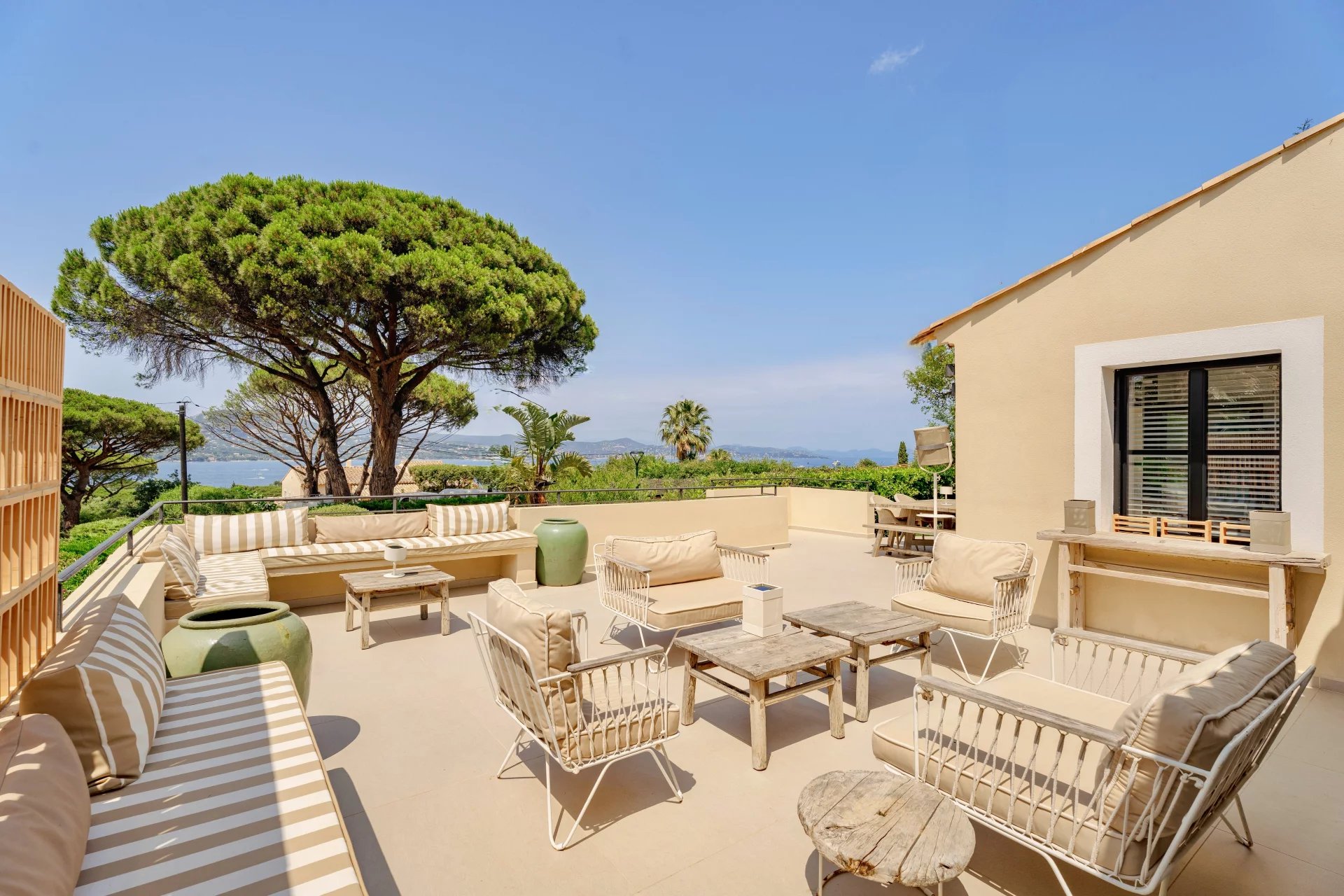 Terrasse de villa à Gassin Terrasse d'une villa avec vue mer à Gassin, mobilier de jardin et végétation environnante.