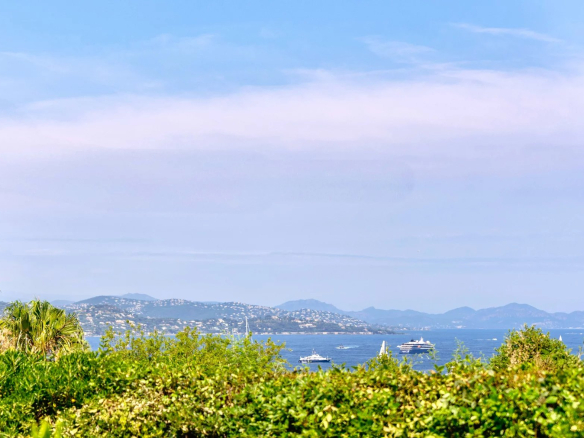 Vue mer depuis une villa à Gassin, avec des bateaux sur l'eau et des collines en arrière-plan.