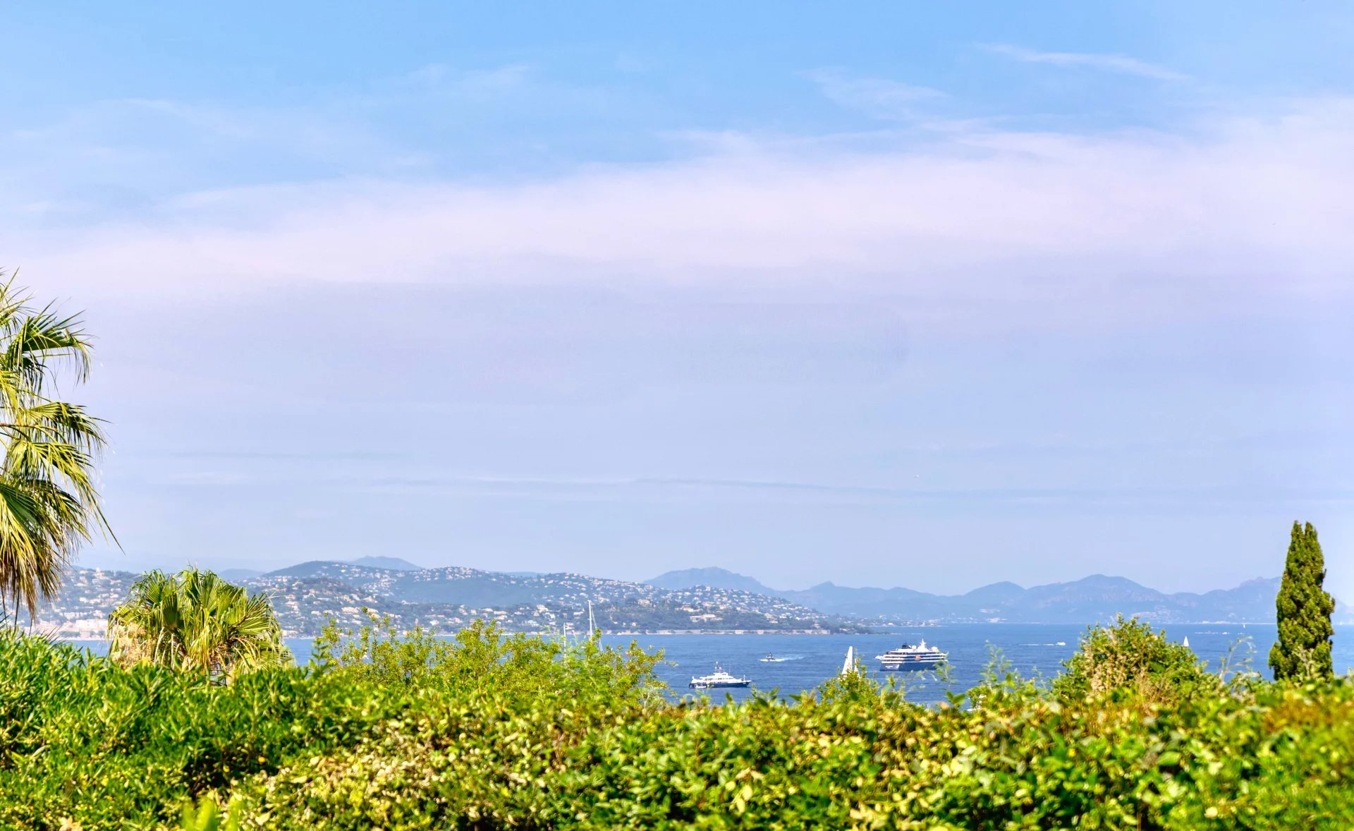 Vue mer depuis la villa à Gassin Vue mer depuis une villa à Gassin, avec des bateaux sur l'eau et des collines en arrière-plan.