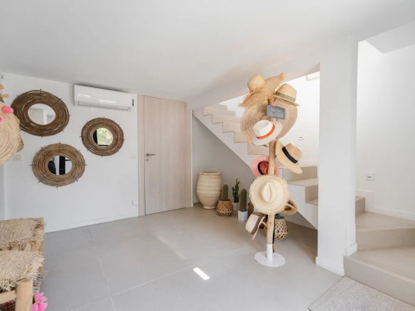 Intérieur d'une villa à vendre à Gassin, avec décoration moderne et chapeaux accrochés au mur.