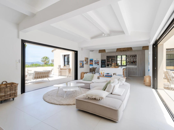 Intérieur lumineux d'une villa moderne avec vue mer, salon ouvert sur terrasse à Gassin.