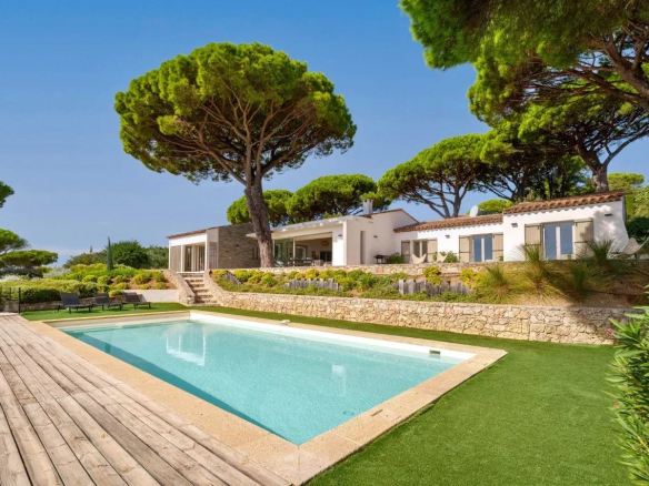 Villa contemporaine de plain-pied avec piscine et vue mer à Sainte-Maxime, entourée de pins.