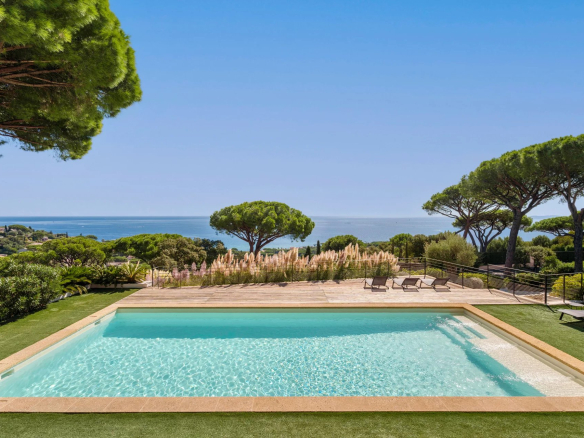 Vue d'une piscine avec mer et paysage verdoyant en arrière-plan à Sainte-Maxime.