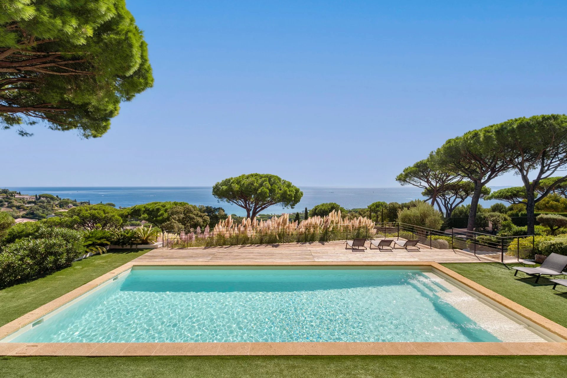 Villa contemporaine avec piscine à Sainte-Maxime Vue d'une piscine avec mer et paysage verdoyant en arrière-plan à Sainte-Maxime.