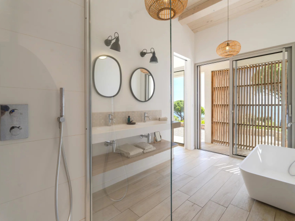 Salle de bain moderne avec douche et baignoire, vue sur l'extérieur, à Sainte-Maxime.
