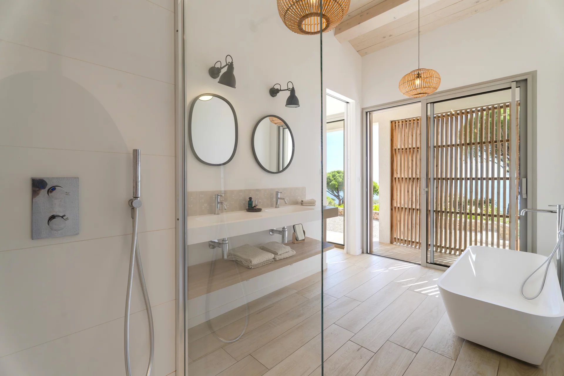 Salle de bain contemporaine à Sainte-Maxime Salle de bain moderne avec douche et baignoire, vue sur l'extérieur, à Sainte-Maxime.