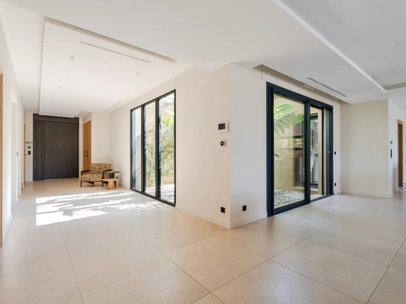 Intérieur d'une villa neuve à Sainte-Maxime, avec lumière naturelle et grandes baies vitrées.