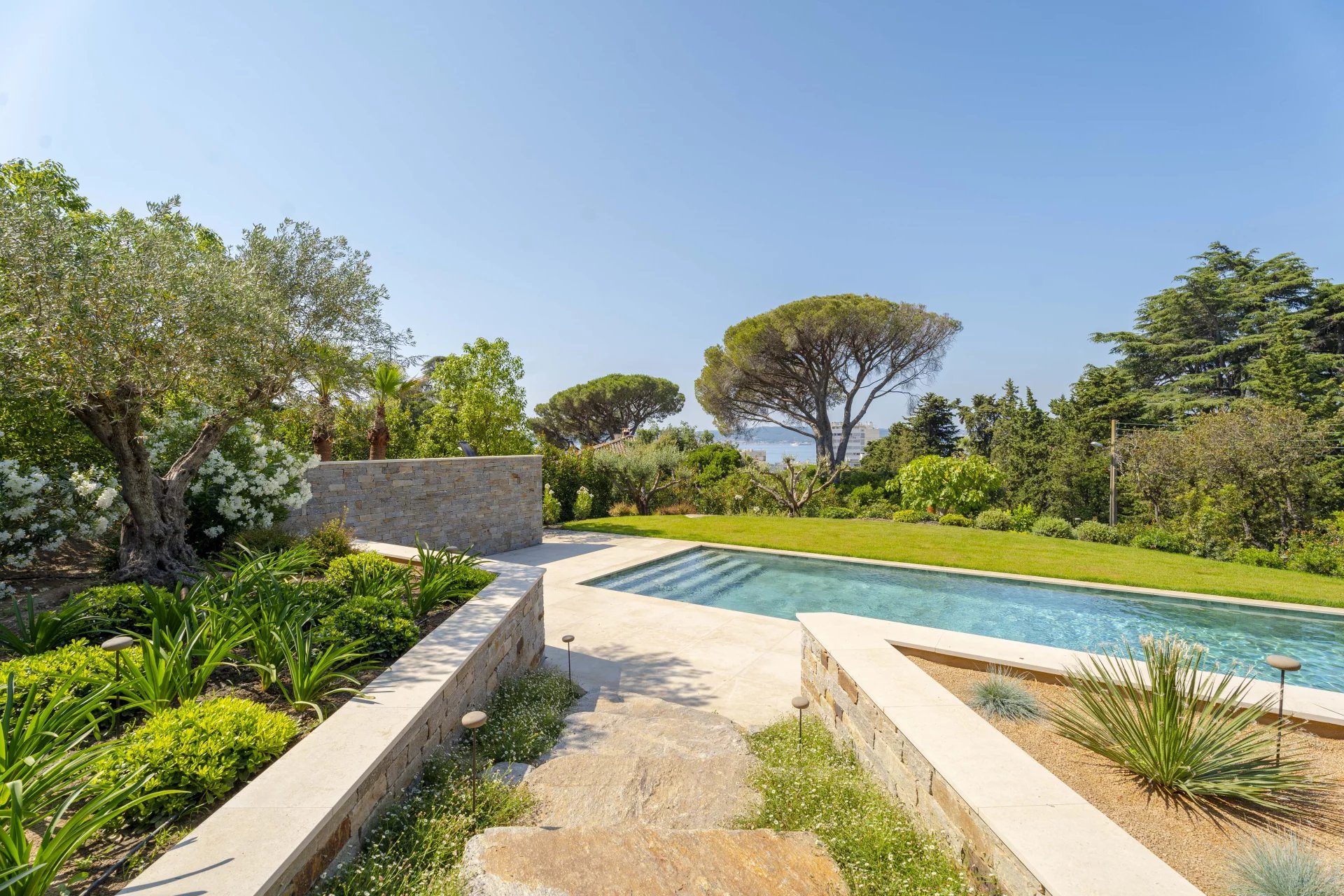 Villa neuve avec piscine à Sainte-Maxime Vue de la piscine et du jardin d'une villa neuve à Sainte-Maxime avec vue sur la mer.