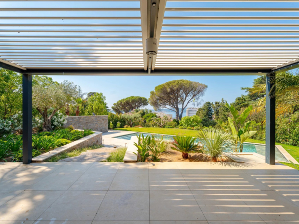 Vue sur la piscine et le jardin d'une villa neuve à Sainte-Maxime, avec des terrasses et des plantations.