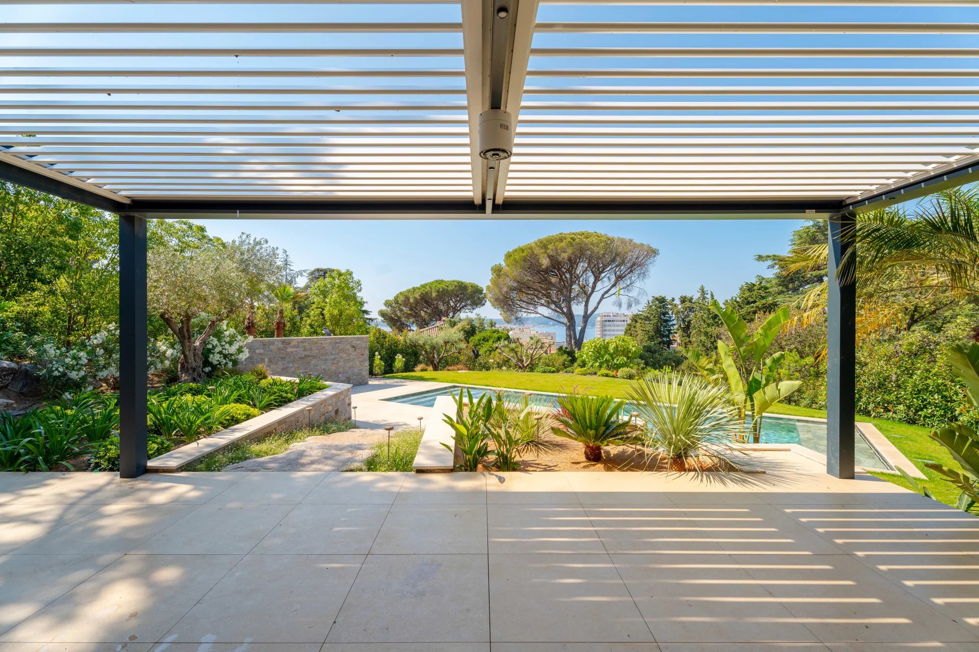 Villa neuve avec vue sur la piscine Vue sur la piscine et le jardin d'une villa neuve à Sainte-Maxime, avec des terrasses et des plantations.